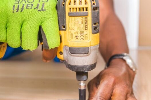 man drilling screw into wooden plank